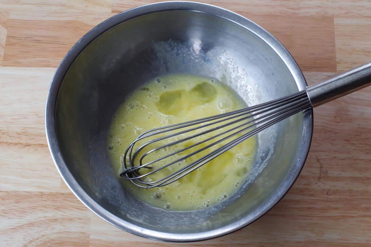 eggs whisked together with a whisk in a stainless steel bowl