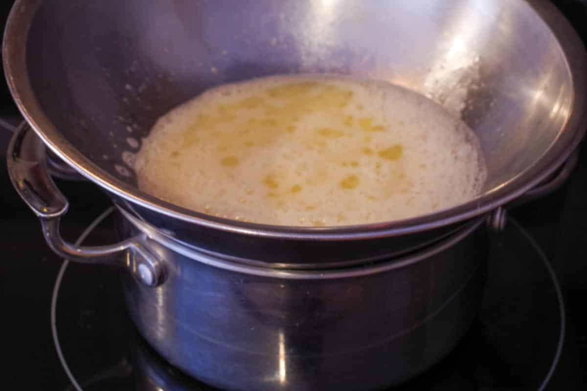 whisked eggs in heatproof bowl, over pot of water, on stove