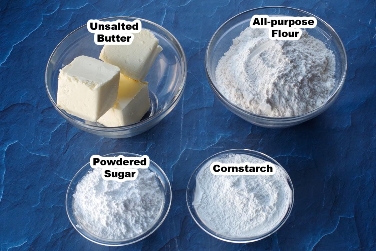whipped shortbread ingredients, labelled, in glass bowls, on blue surface