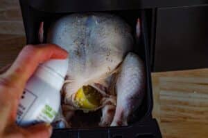 whole roast chicken being sprayed with oil