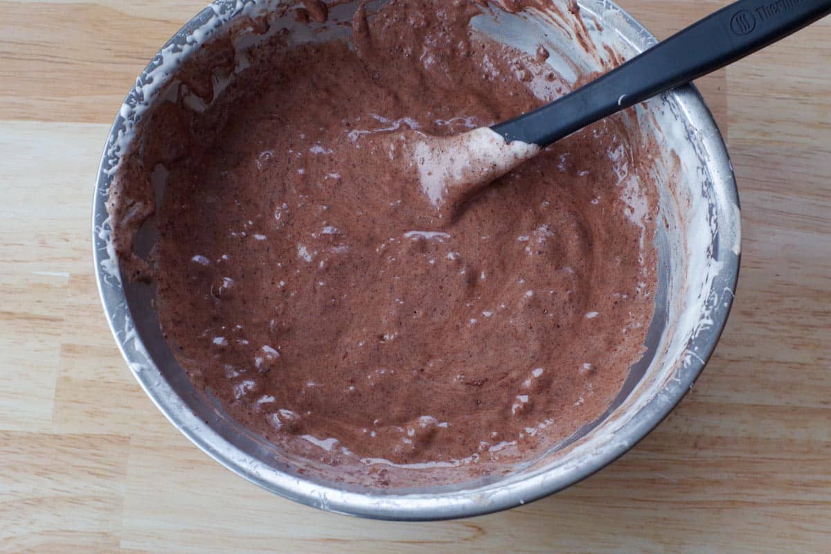 sponge batter mixed together in stainless steel bowl with black spatula
