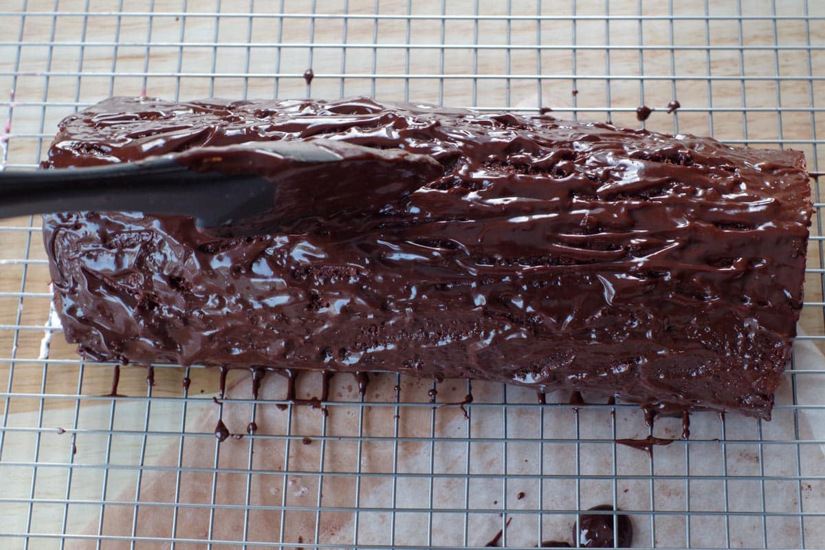ganache poured on cake and spatula etching lines in it