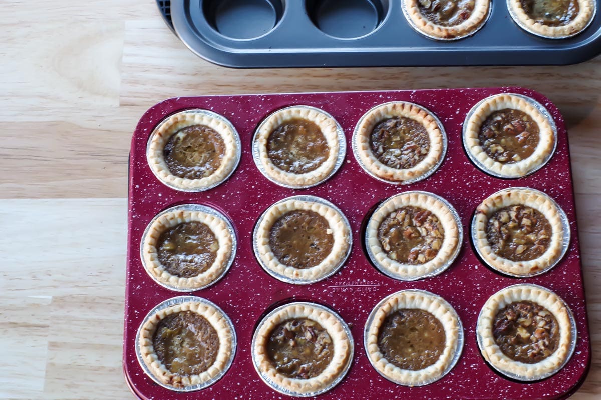 cooked butter tarts in red speckled muffin tin