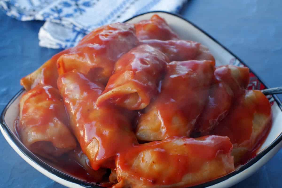 cooked cabbage rolls in a Ukrainian dish on blue surface