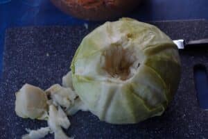 Core being removed from cabbage with a knife