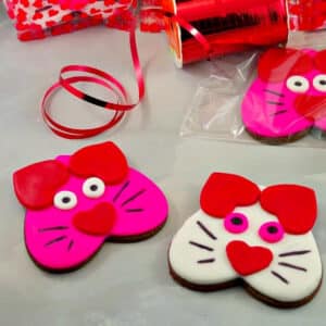 pink and white cat cookies on grey surface