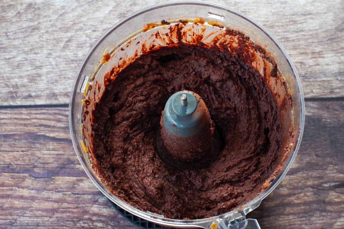 chocolate chips added to chocolate hummus in bowl of food processor