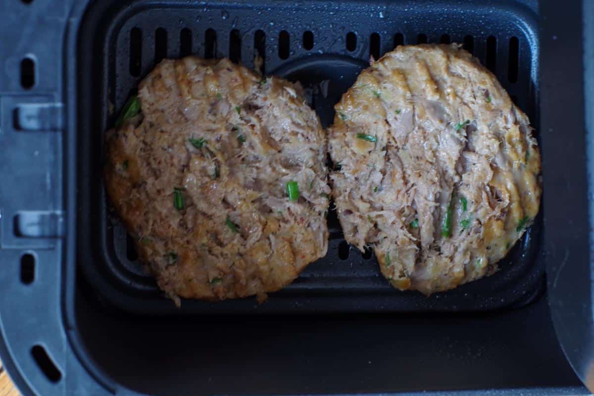tuna burgers flipped over in air fryer.
