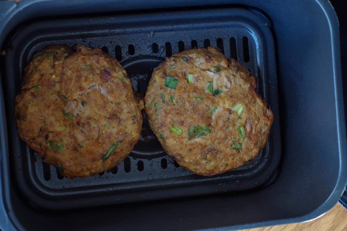 cooked tuna burgers in air fryer basket or drawer