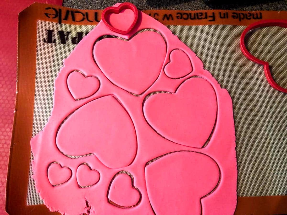 pink fondant rolled out with heart shapes cut into it
