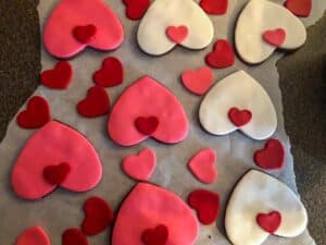 small heart cat noses being put on heart-shaped cookies