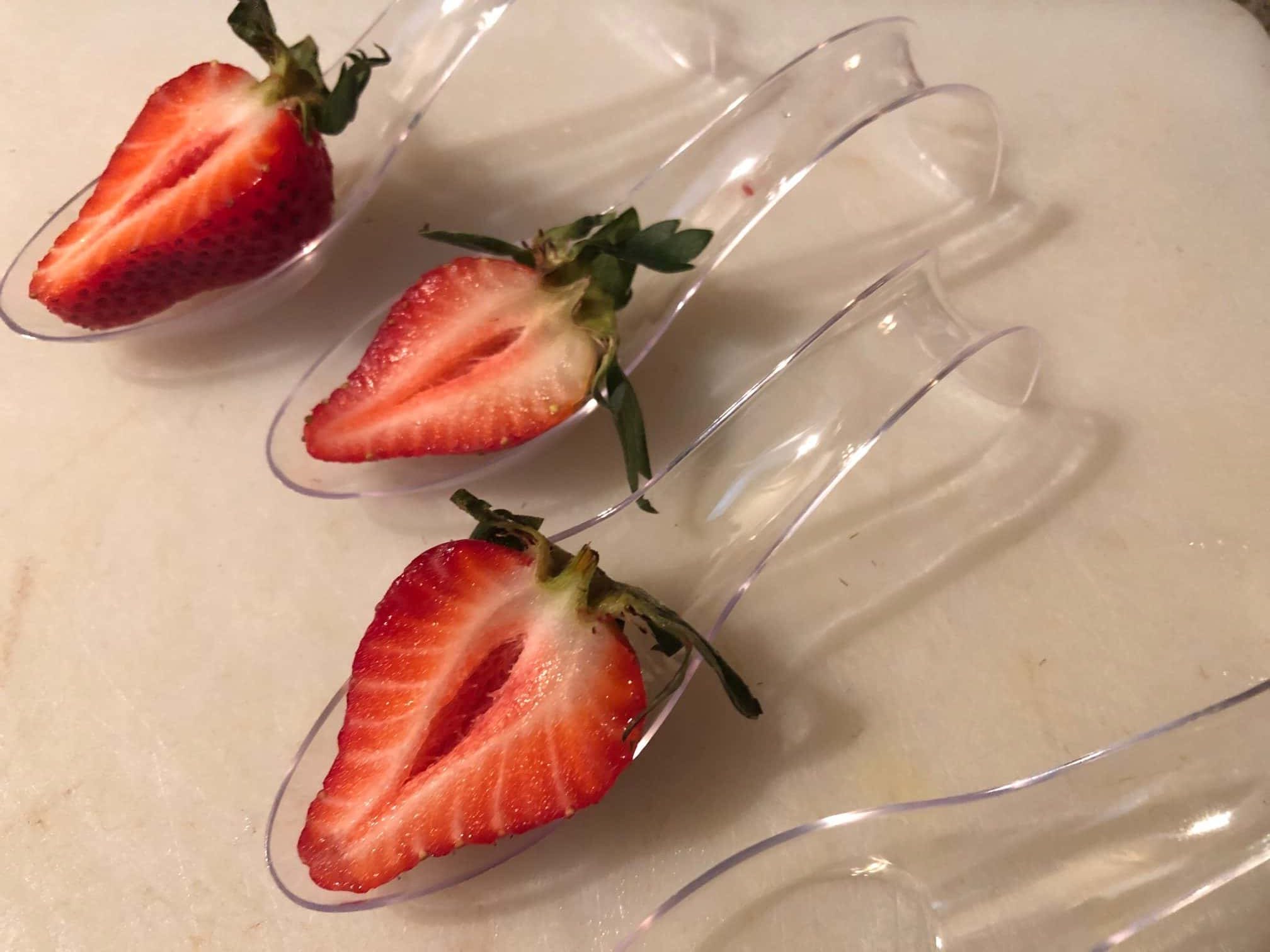 strawberries cut in half in bottom of spoon