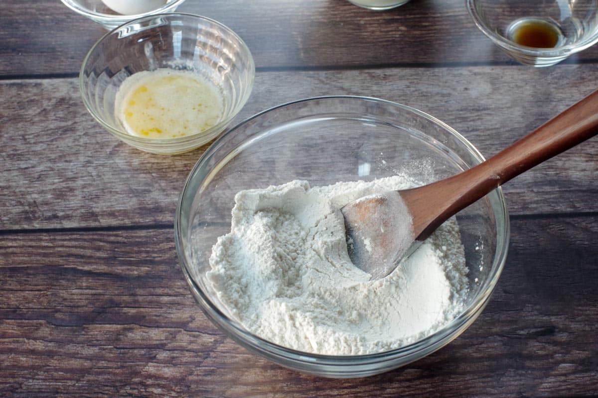 dry ingredients mixed together in glass blow with wooden spoon