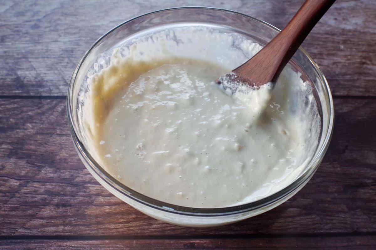 batter mixed together in a glass bowl with a wooden spoon