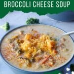 pin with white text on green background on top and bottom and photo of broccoli cheese soup in a blue bowl with a spoon, with broccoli scattered around