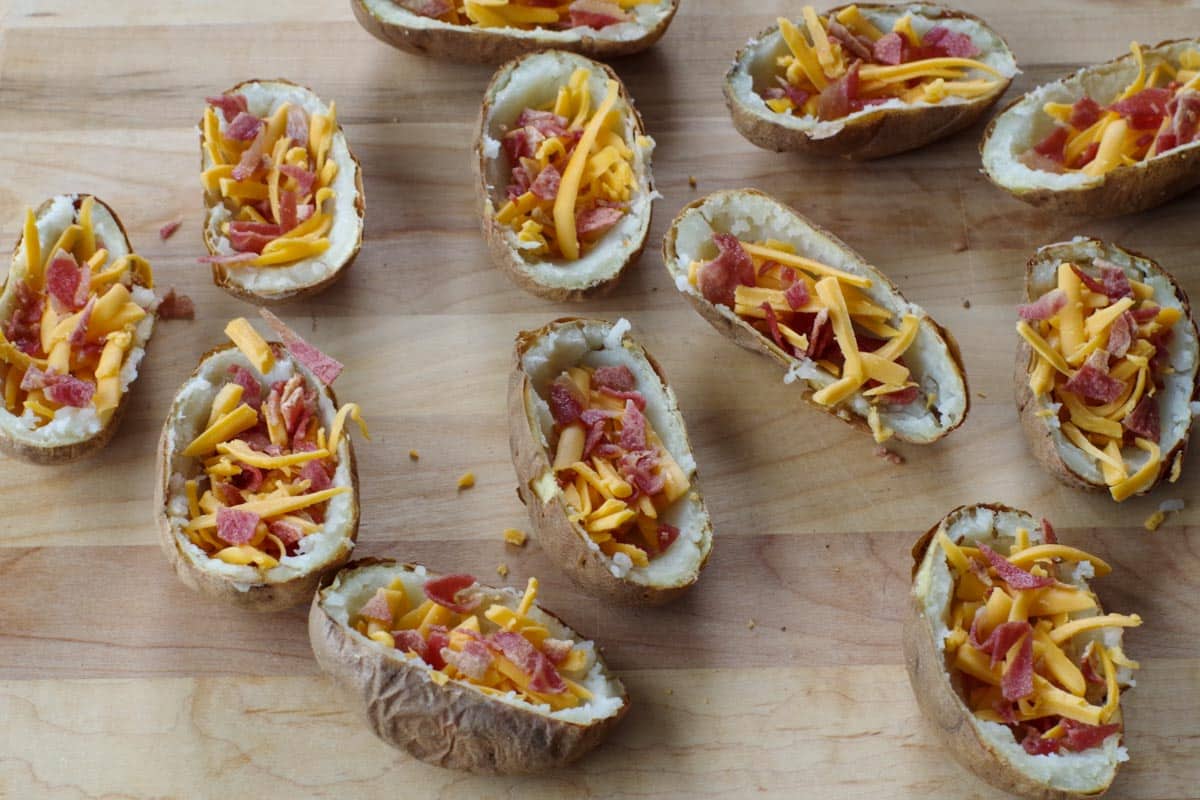 potato skins with cheese and bacon on wooden cutting board