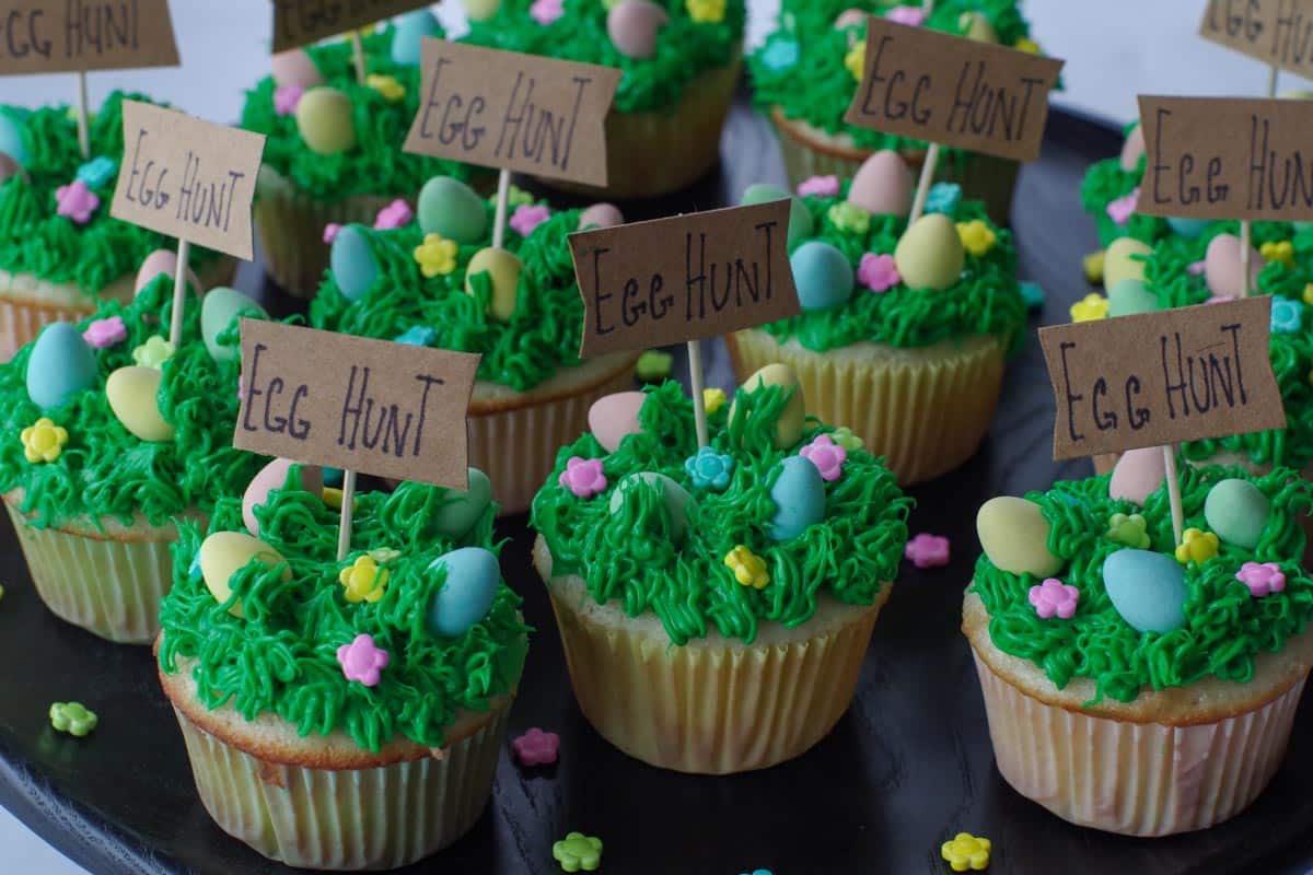 a dozen Easter cupcakes with mini eggs on a black platter
