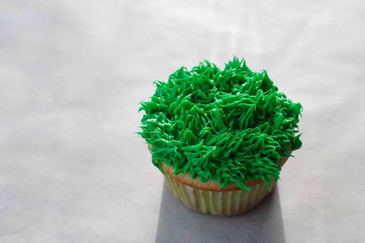 cupcake covered in green grass frosting