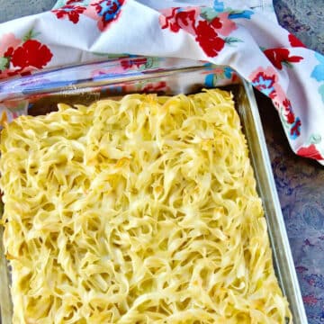 egg noodle casserole in glass dish with paper towel in background