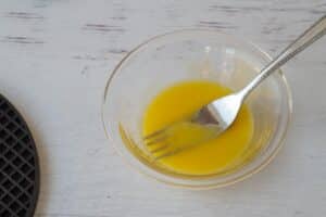 egg yolks in glass bowl with fork