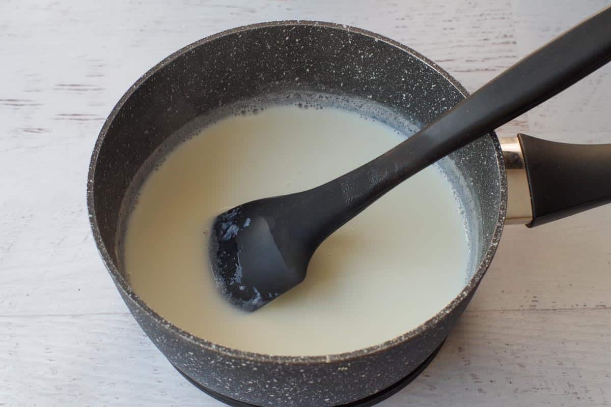 scalded milk in a pot with a black spatula