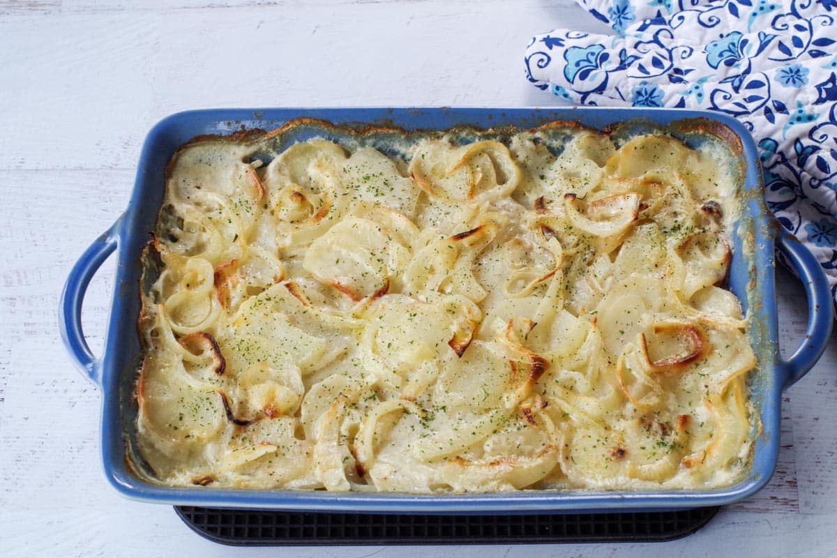 baked scalloped potatoes in a blue casserole dish