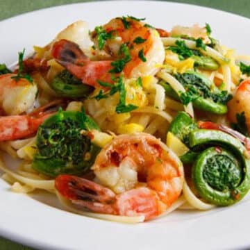 fiddlehead shrimp scampi in a white dish