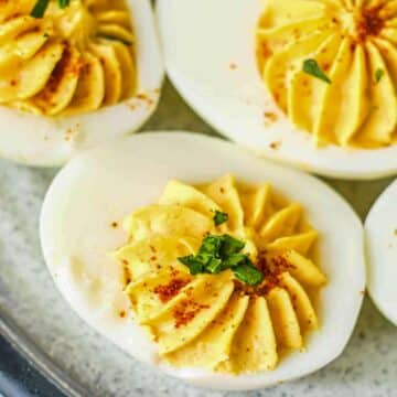 3 Mexican deviled eggs photographed from above, on a grey plate