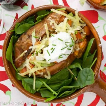 Mexican Stuffed Sweet Potato on a bed of lettuce in a brown bowl