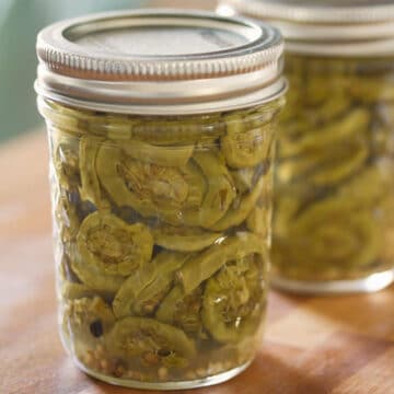 2 jars of pickled fiddleheads on wooden surface