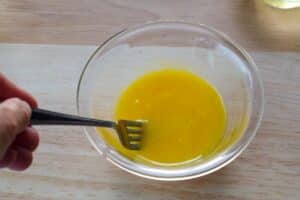 egg yolks being beaten with a fork
