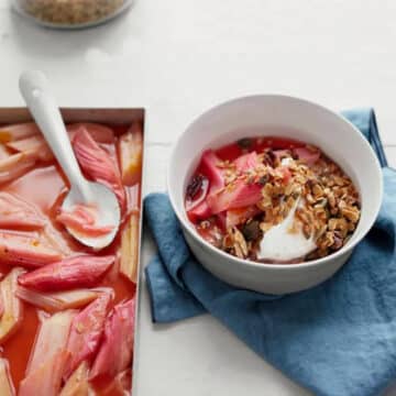 bowl of rhubarb granola, with pan of roasted rhubarb on the side