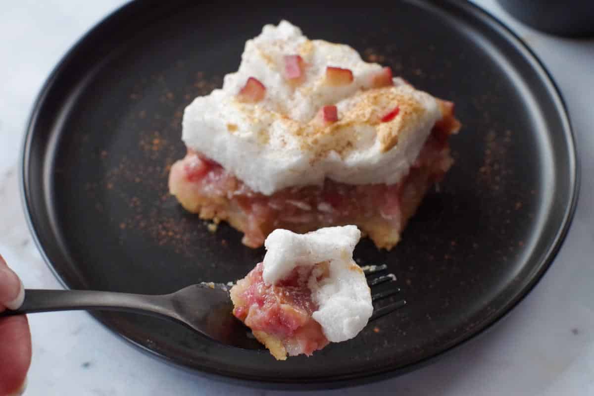 a bite of rhubarb torte being held up on a fork