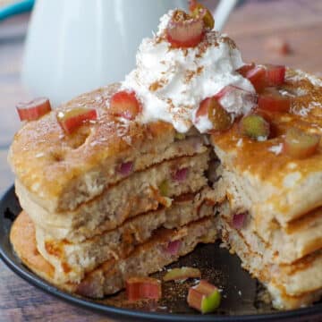 4 stacked rhubarb pancakes with piece cut out of middle