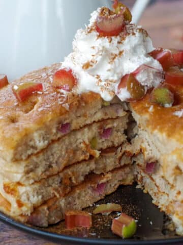 4 stacked rhubarb pancakes with piece cut out of middle
