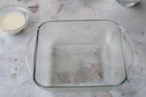 glass pan sprayed with non-stick cooking spray on a counter