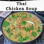 Slow cooker Thai chicken soup in a black bowl with a spoon and more bowls in the background