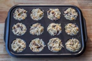 mixture scooped into prepared muffin tin and packed down