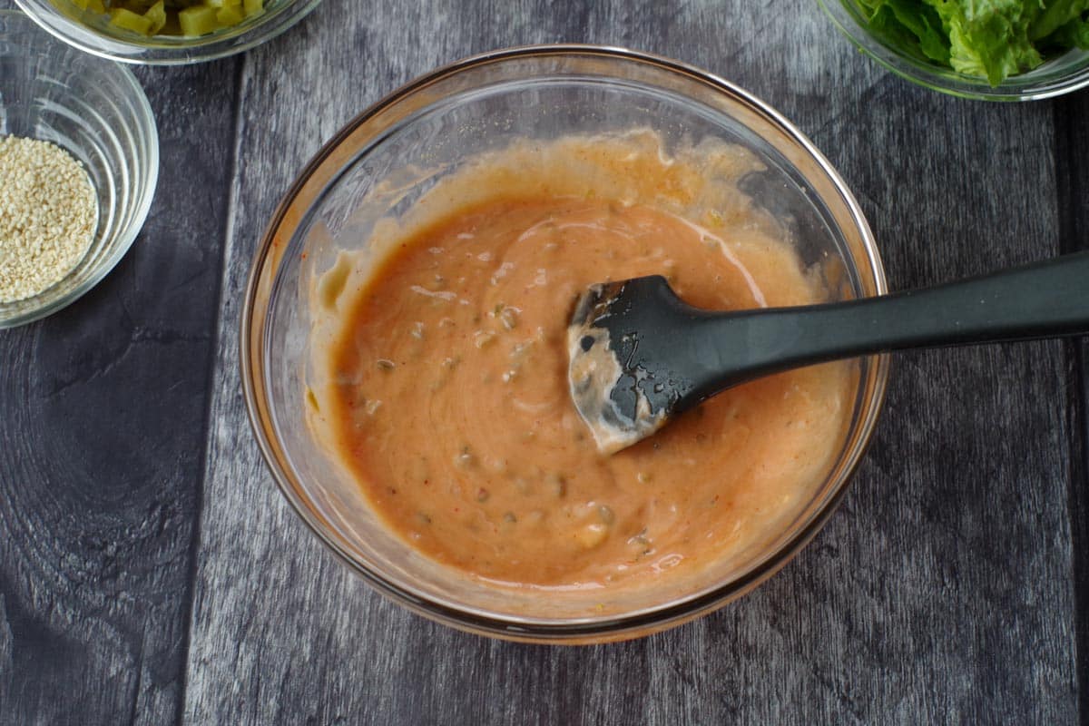 Pizza sauce ingredients in a medium glass bowl, with a spatula