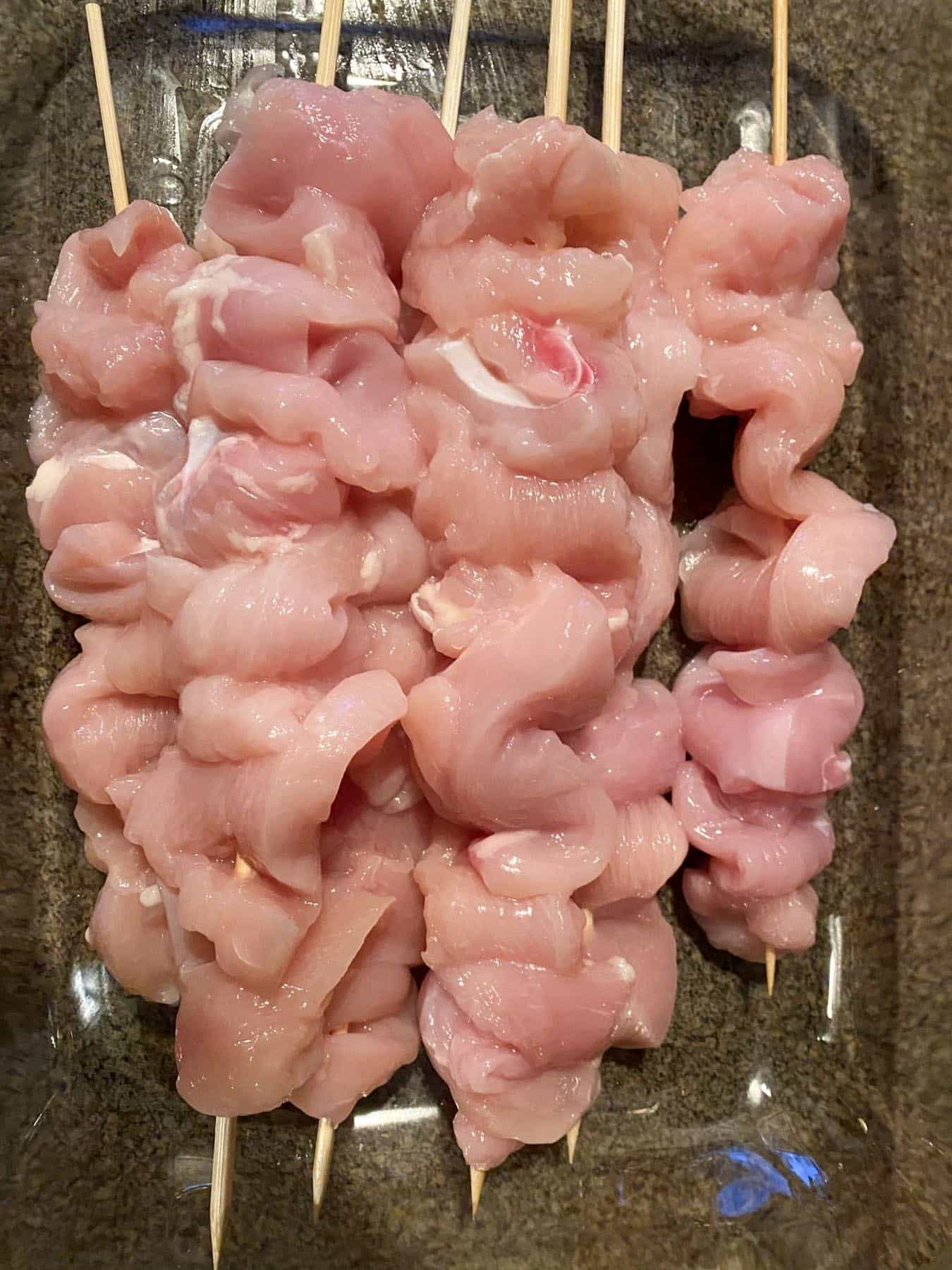 all chicken pieces on skewer in a container