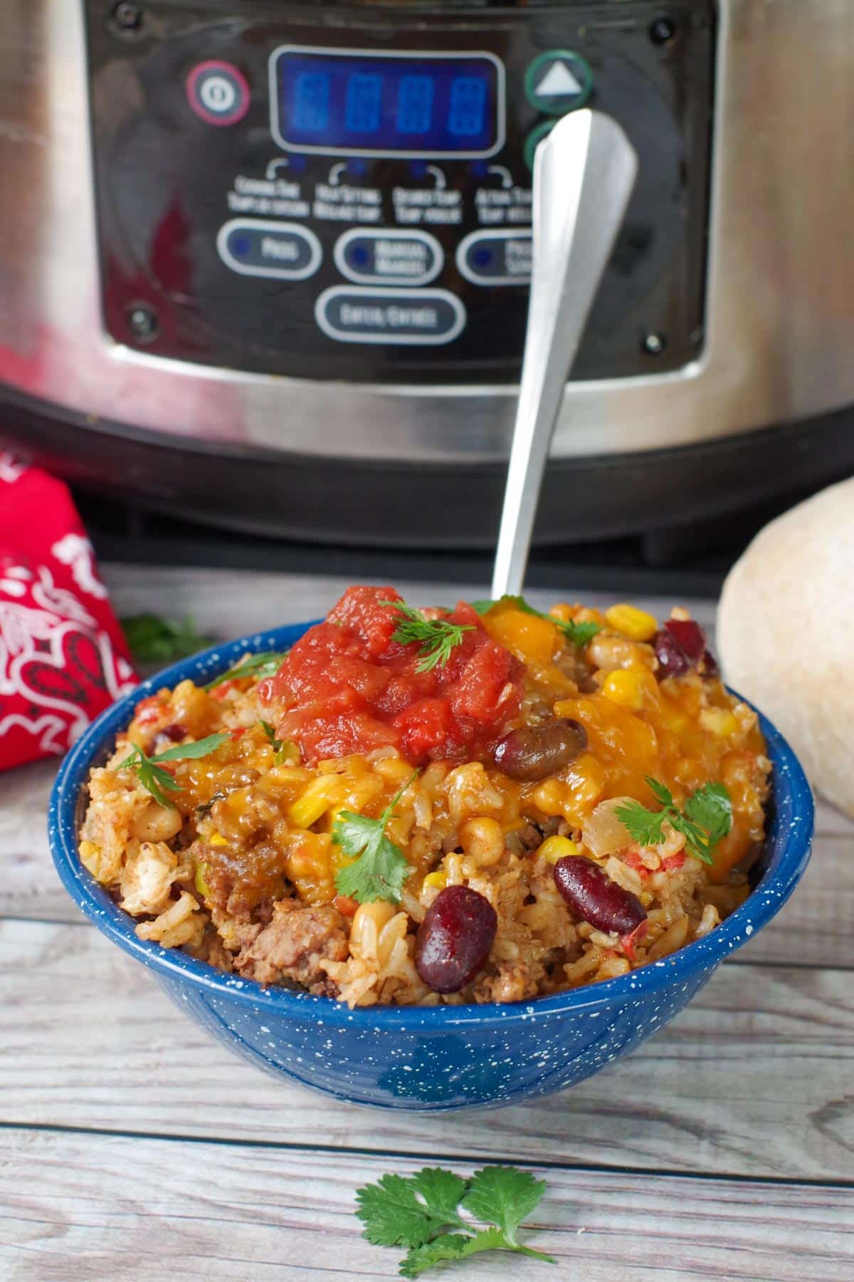 a bowl of cowboy casserole in front of a crock pot