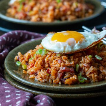 Gochujang fried rice in a bowl with egg on top and more rice in background