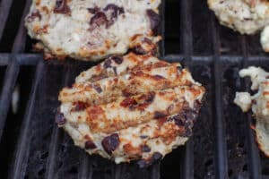Grilled Greek chicken burgers on grill