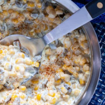 Jalapeno creamed corn in a metal bowl, with a metal serving spoon
