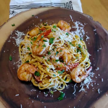 spicy shrimp pasta on a brown wooden platter