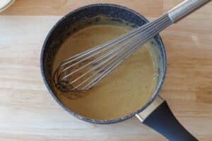 butter tart sauce thickened to consistency of gravy, in saucepan, with whisk