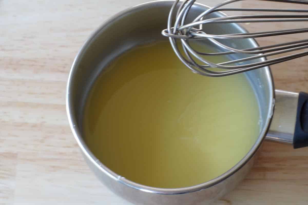 glaze ingredients whisked together in a small pot, with a whisk