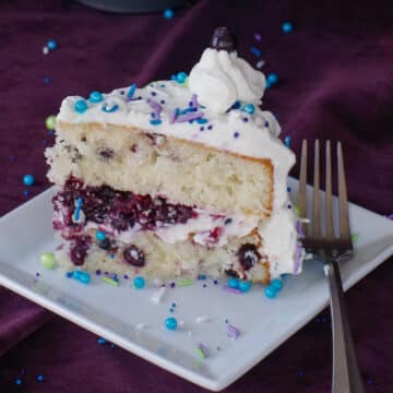 a piece of Saskatoon berry cake on a white plate with a fork