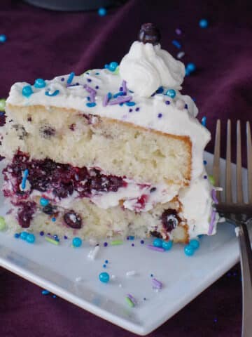 a piece of Saskatoon berry cake on a white plate with a fork