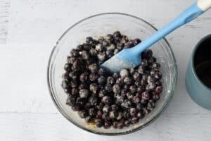 Saskatoons in bowl with other filling ingredients, with a blue spatula